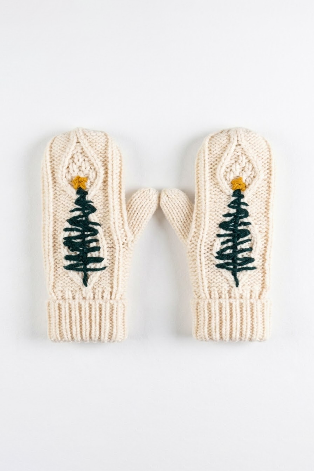 Cable knit mittens with an embroidered tree