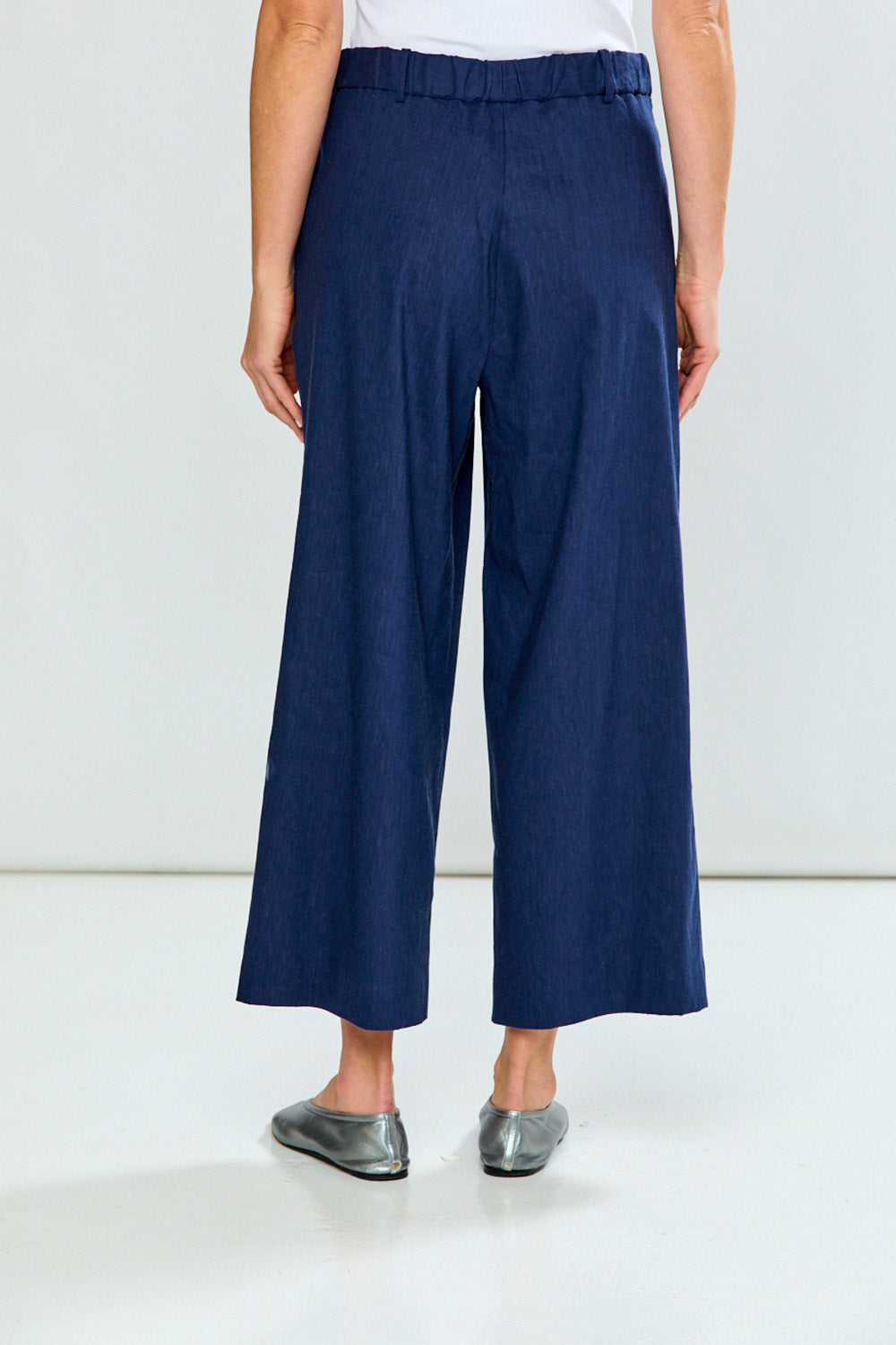 Navy blue wide-leg pants worn by a person on a white background