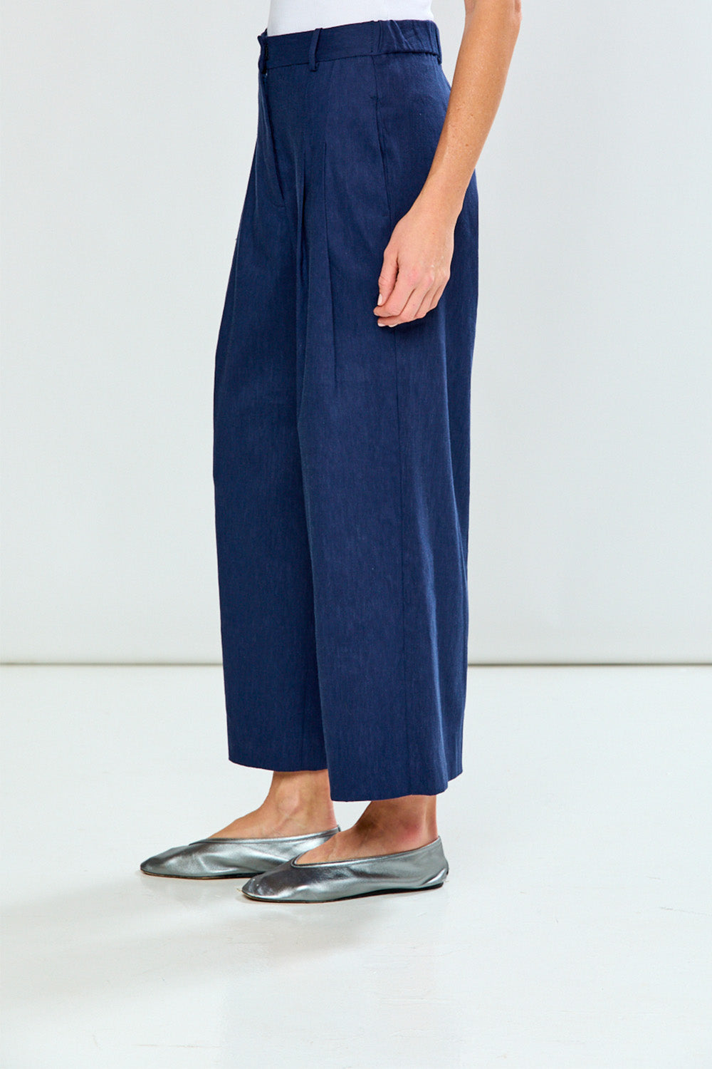 Navy blue wide-leg pants worn by a person on a white background