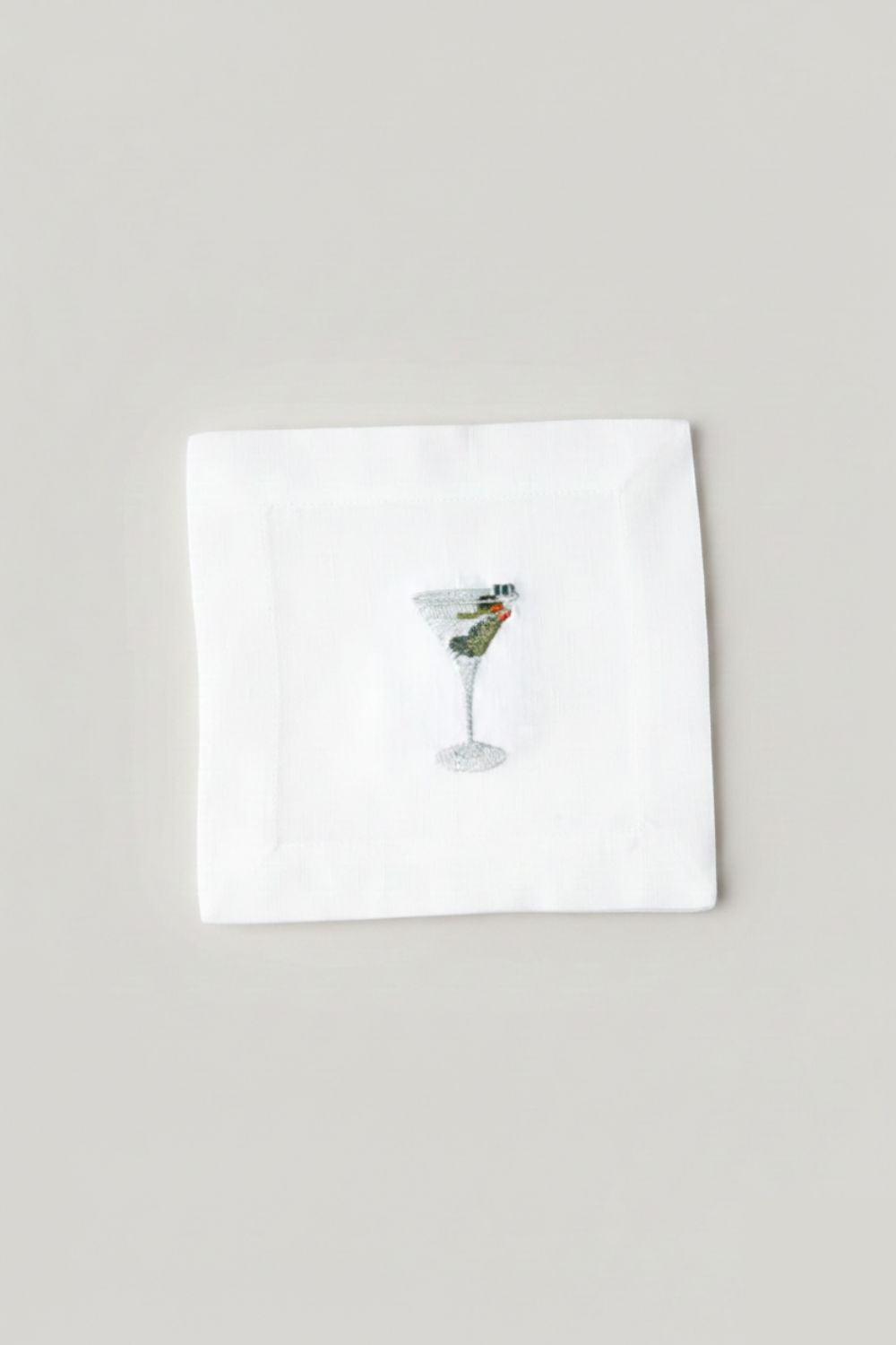 White napkin with a cocktail illustration on a light gray background