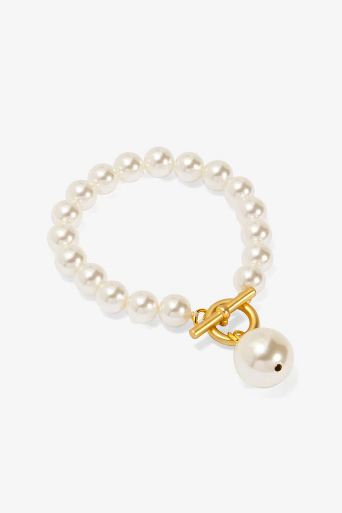 The Single Strand Pearl Bracelet featuring lustrous white pearls with a gold toggle clasp and dangling pearl charm in a classic sophisticated style