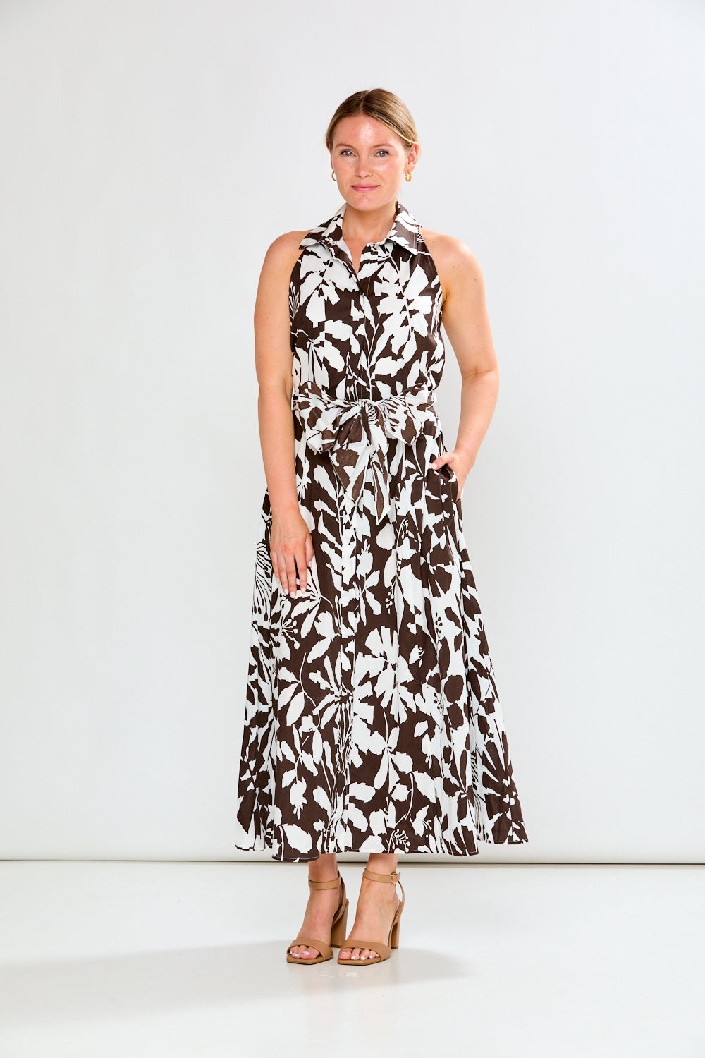 Woman wearing a sleeveless floral dress on a white background