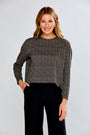 Woman wearing a plaid top with black pants on a light gray background
