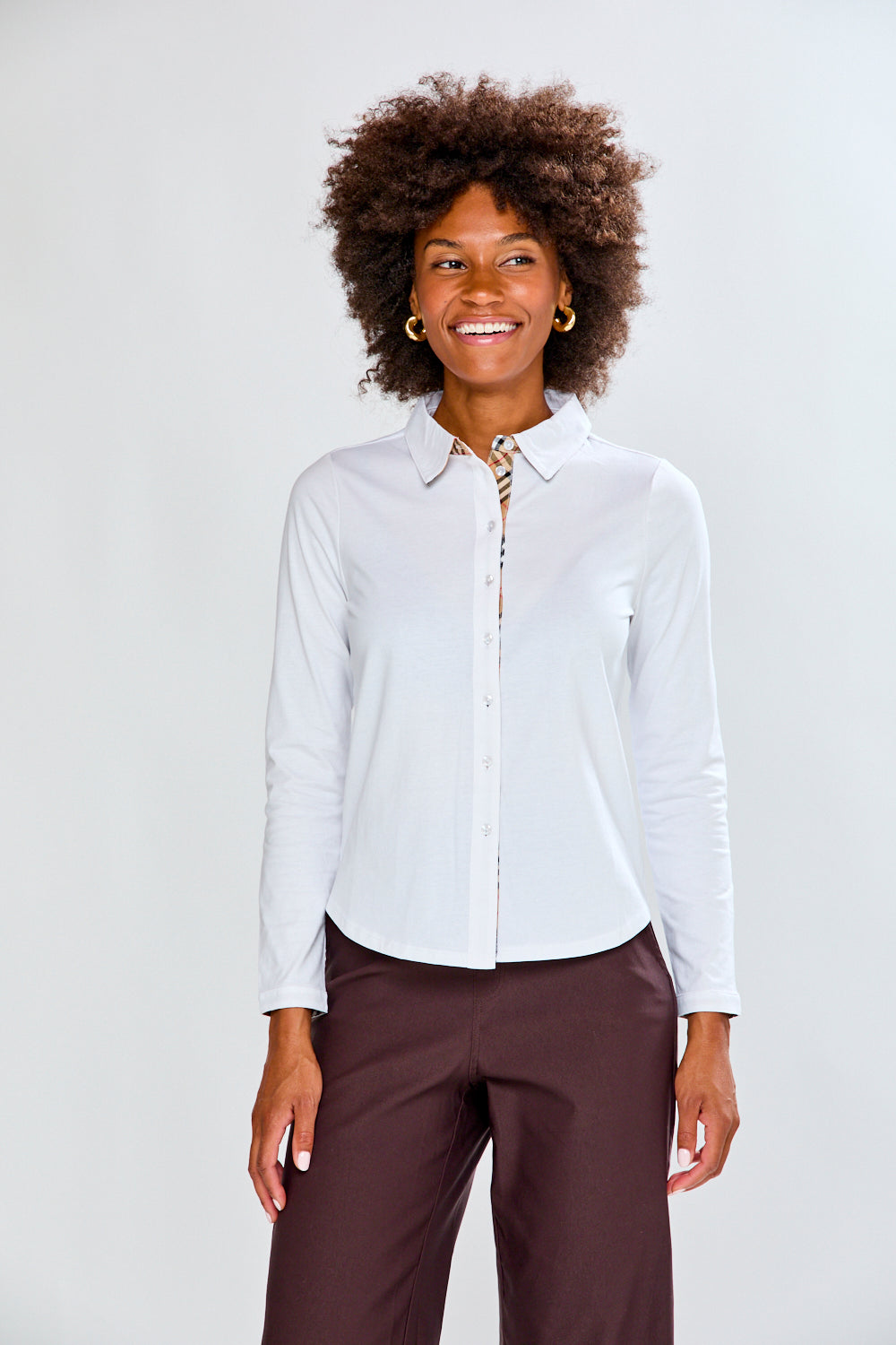 Woman wearing a white shirt and brown pants on a white background