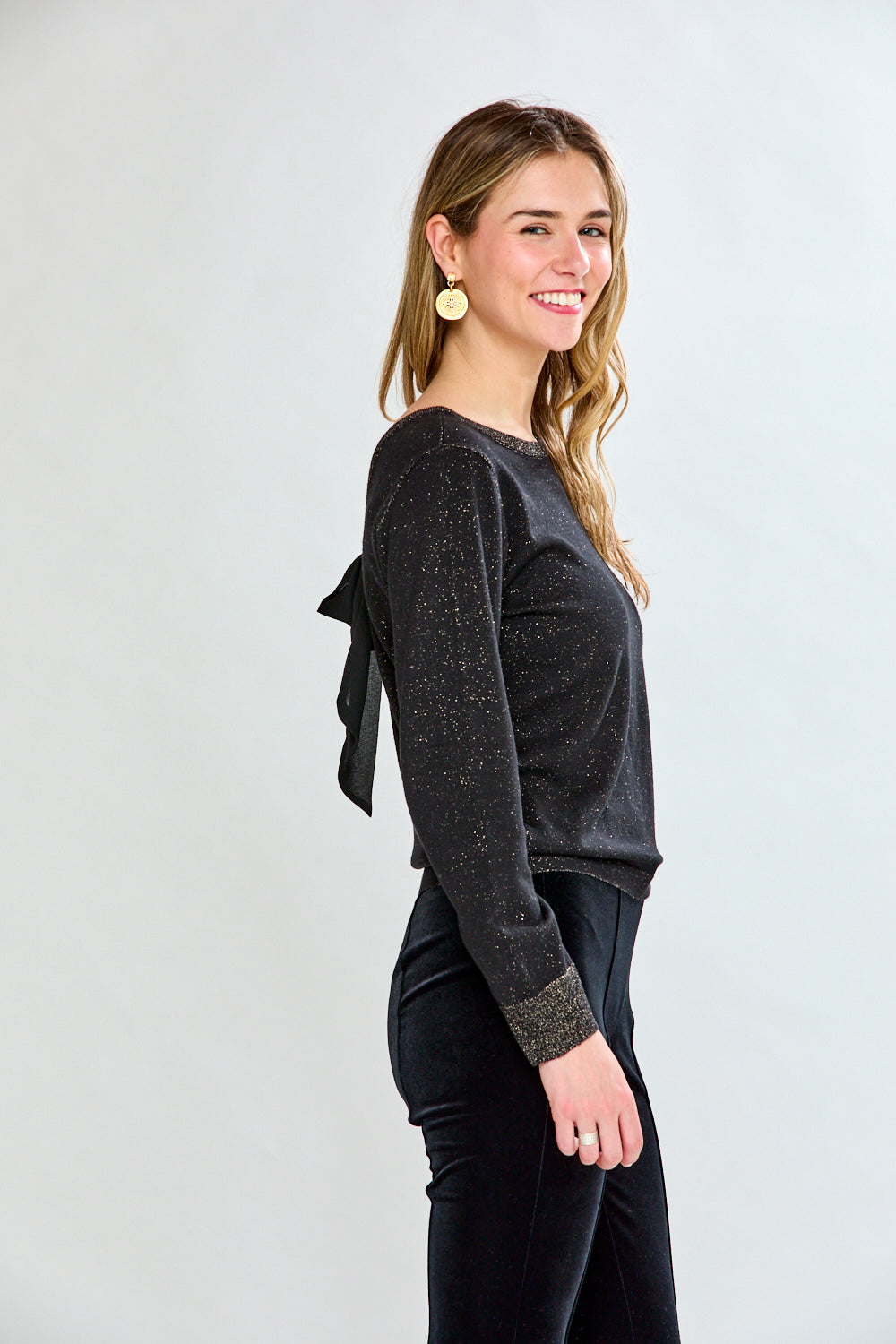 Woman wearing a black sweater and black pants on a white background