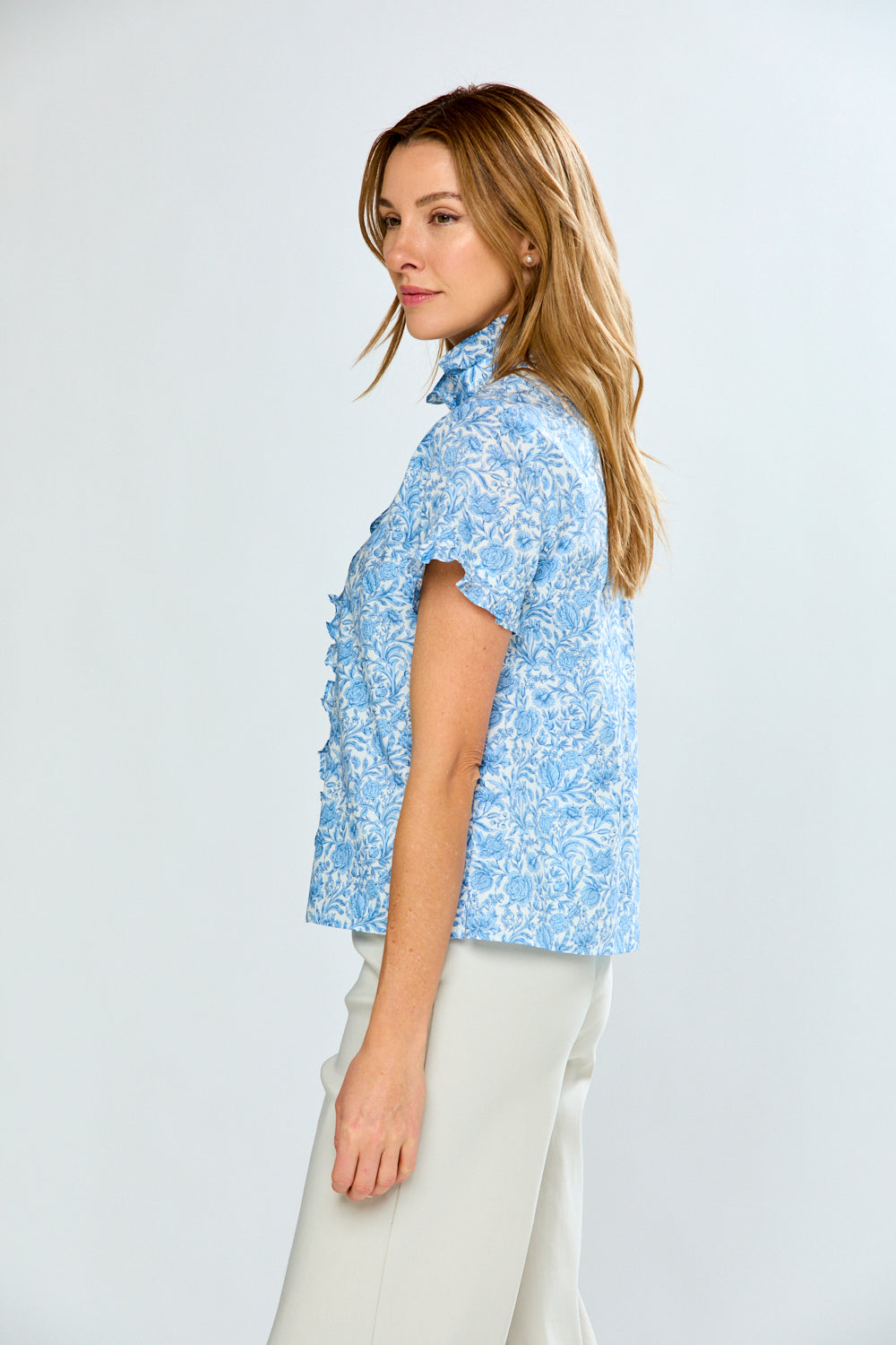 Woman wearing a blue floral blouse against a white background