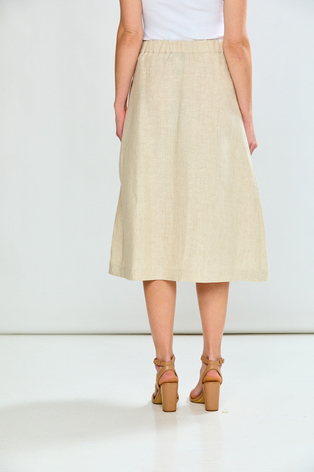 Person wearing a beige skirt on a white background