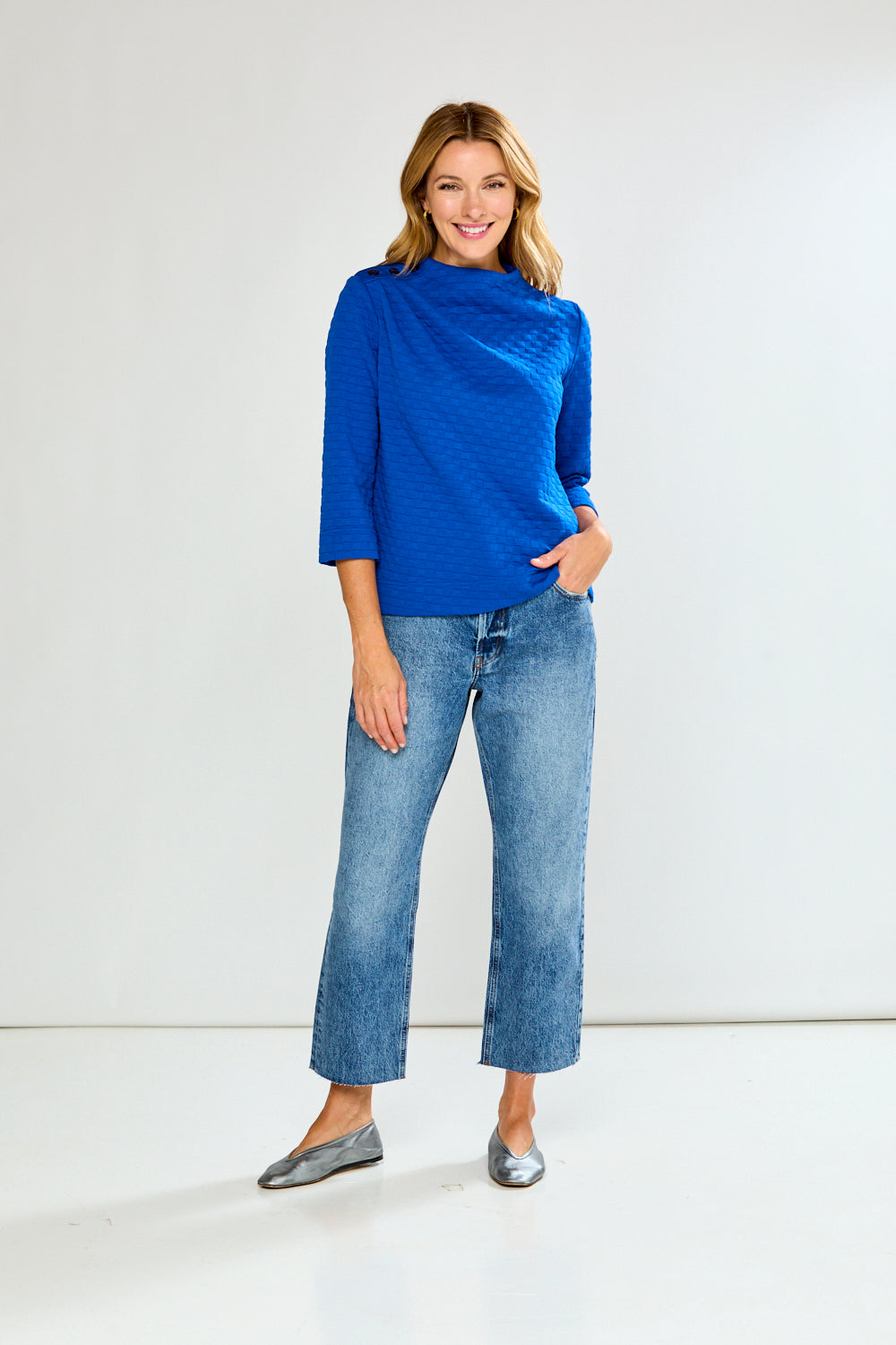 Woman wearing a blue sweater and jeans on a white background