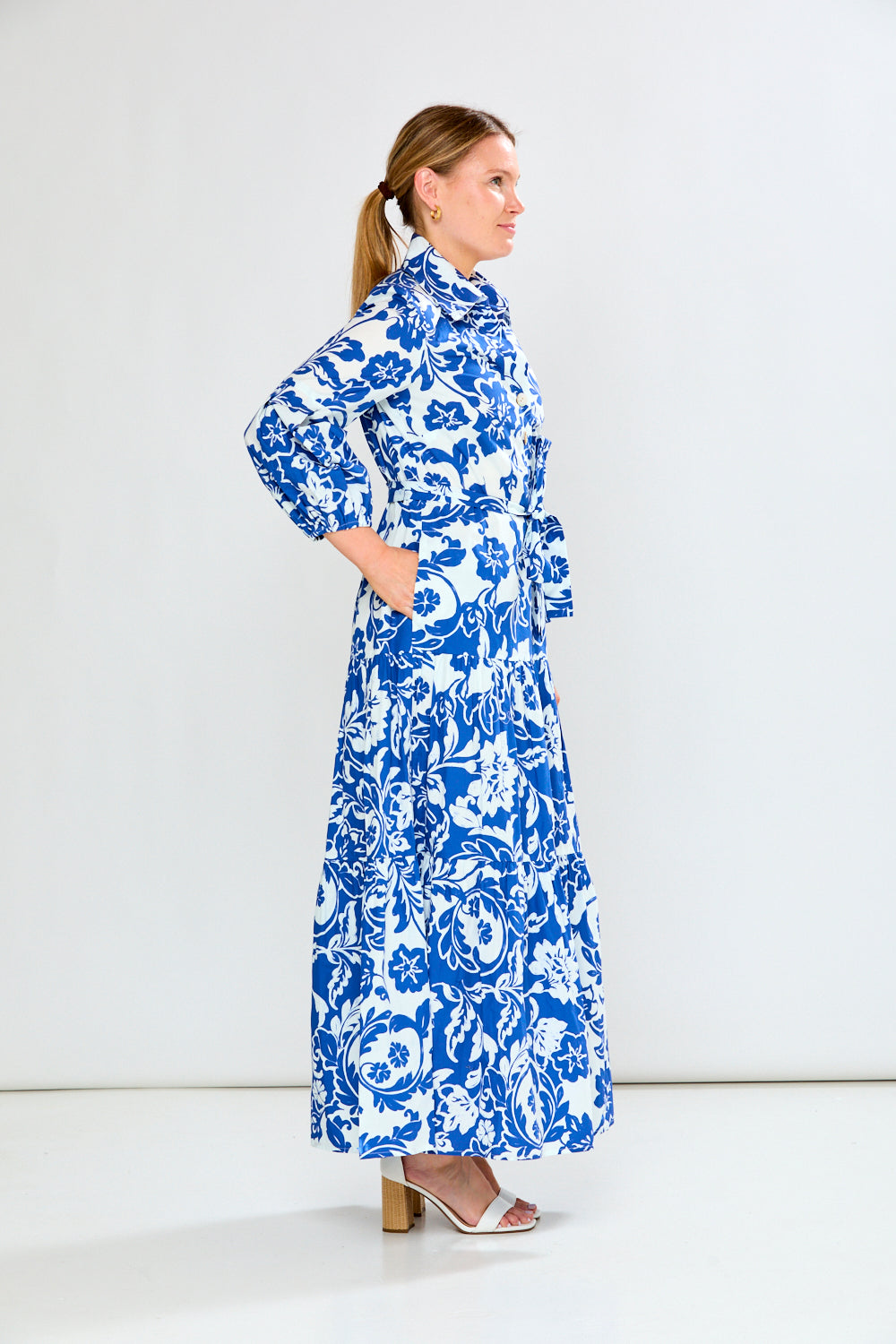 Woman wearing a blue and white floral dress on a white background