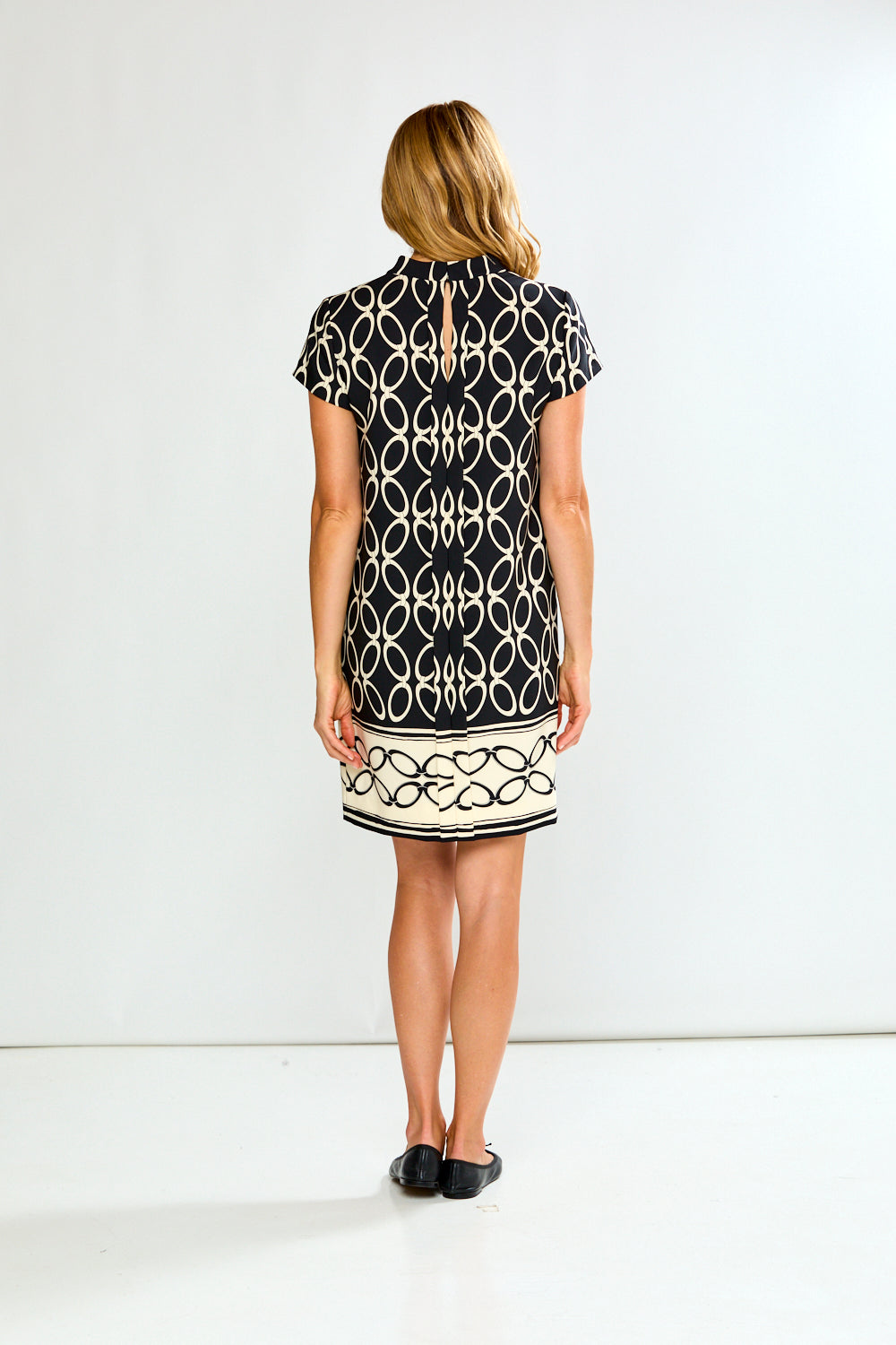Woman wearing a black and white patterned dress on a white background