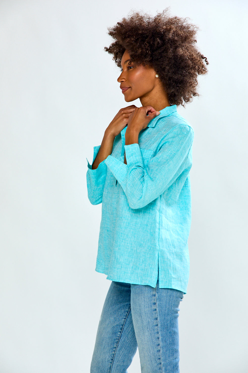 Woman wearing a light blue shirt and jeans on a white background