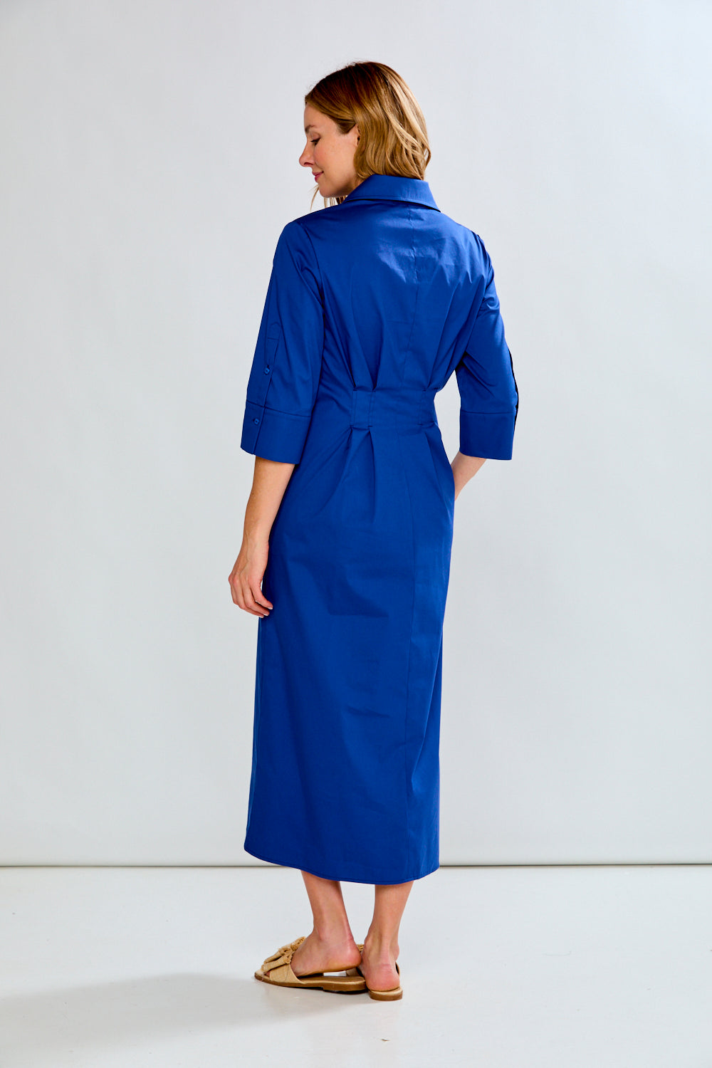 Woman wearing a blue dress against a white background