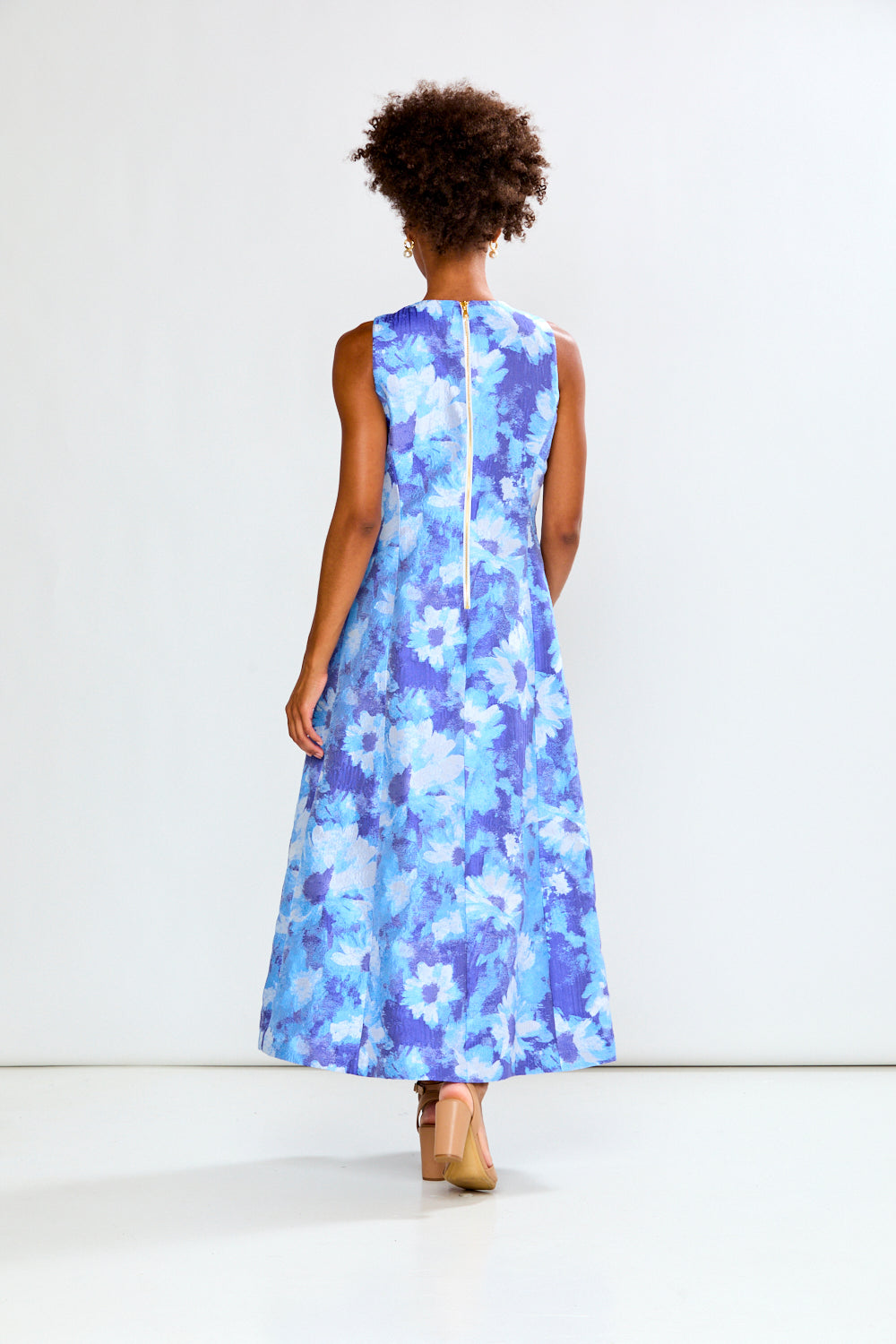 Woman wearing a blue floral dress on a white background