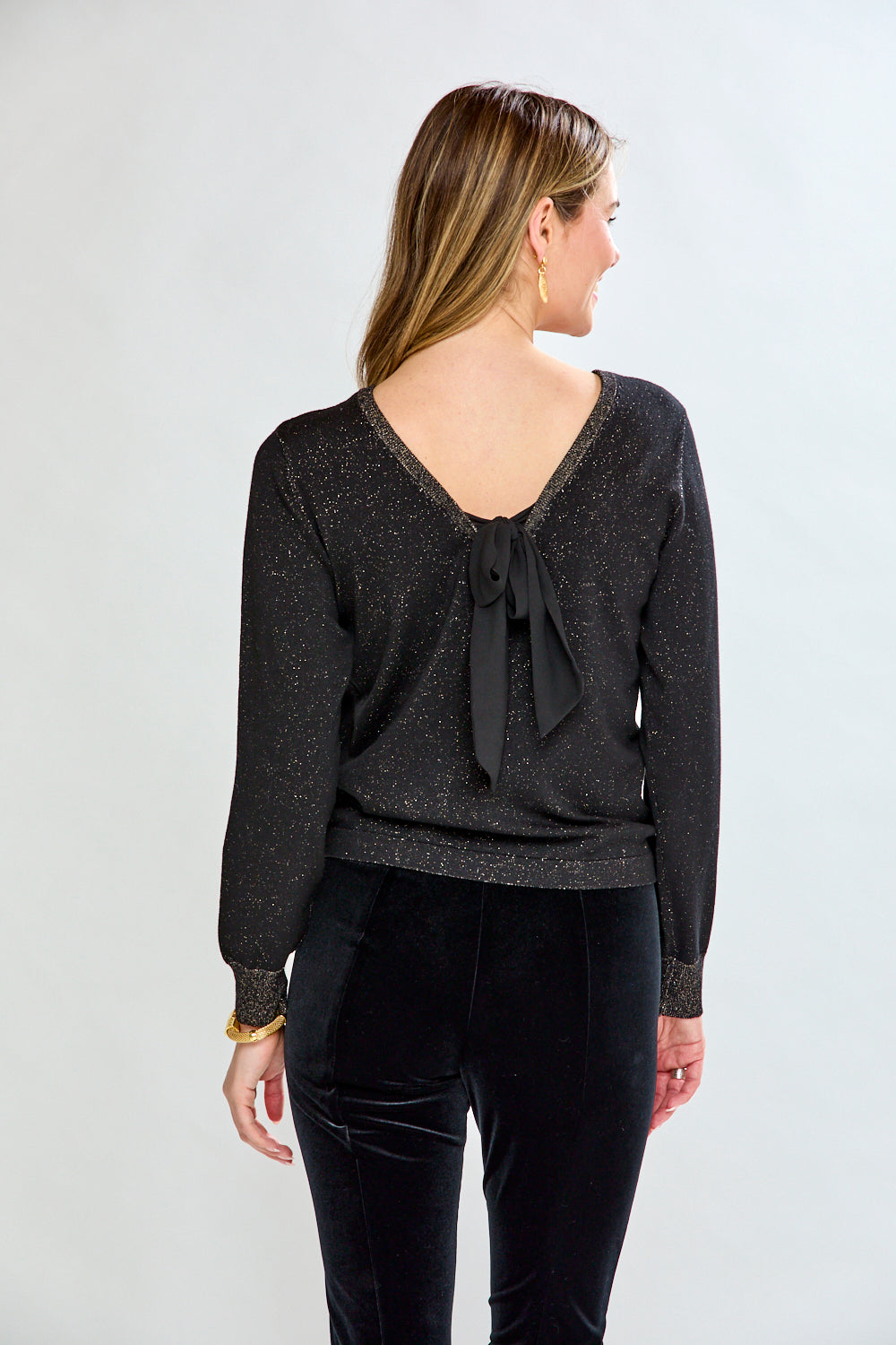 Woman wearing a black sweater and black pants on a white background