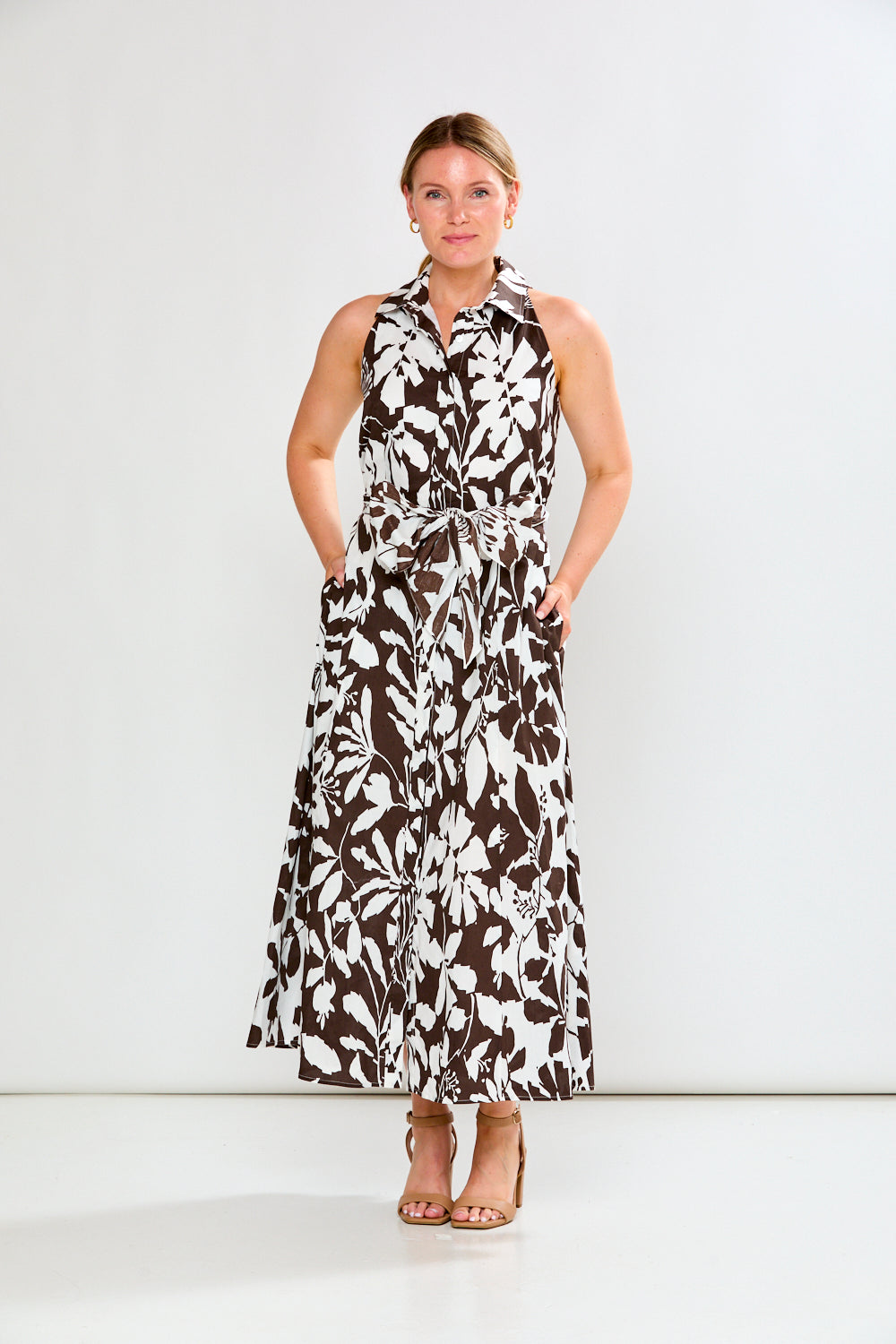 Woman wearing a sleeveless floral dress on a white background