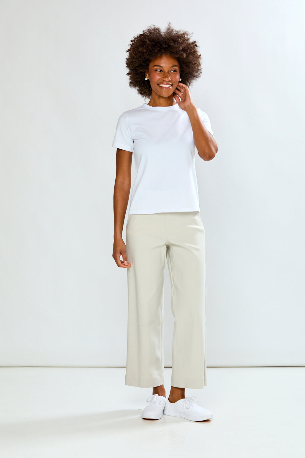 Person wearing a white t-shirt and beige pants on a white background