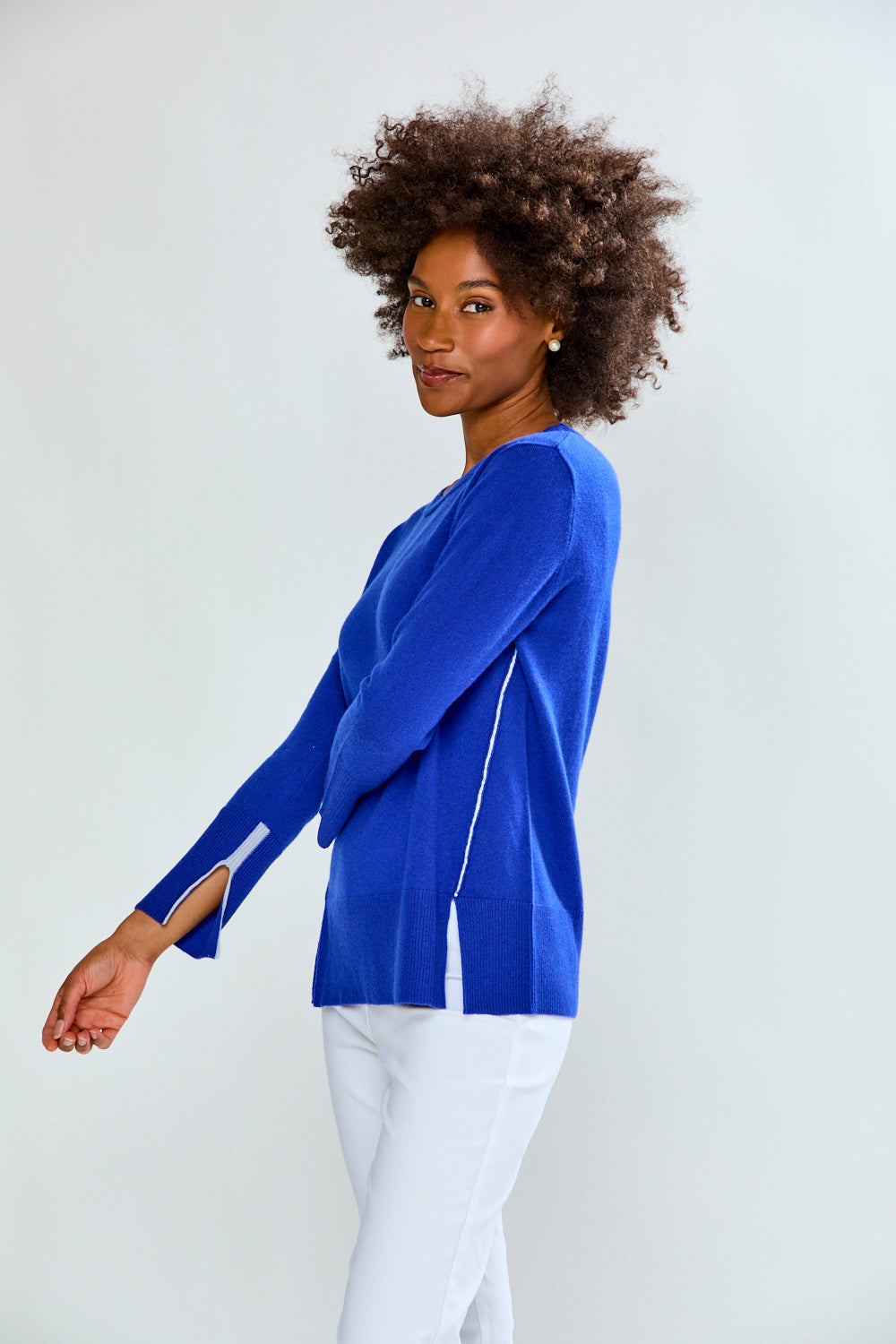 Woman wearing a blue long-sleeve top against a white background