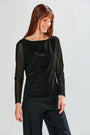 The Selena Top in Velvet - Black shown on a model with a boat neckline and sheer long sleeves in a sophisticated black velvet design