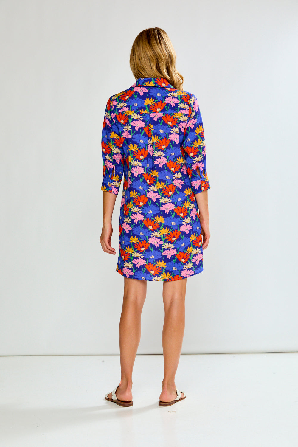 Woman wearing a colorful floral dress on a white background