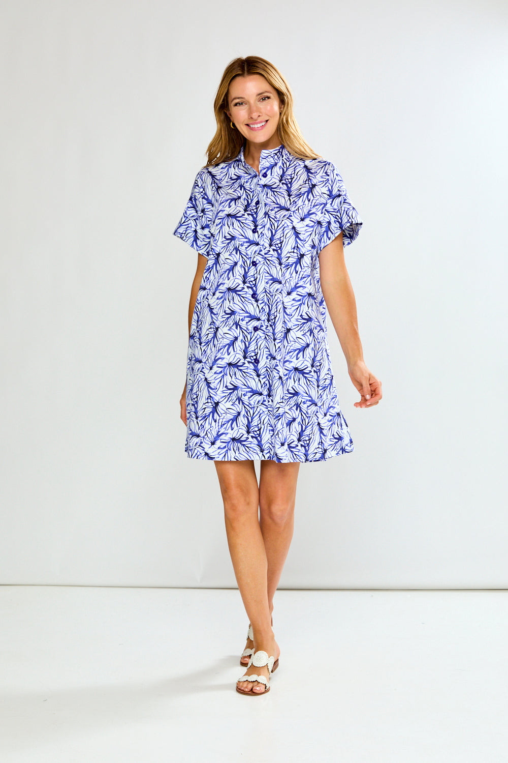 Woman wearing a blue floral dress against a white background