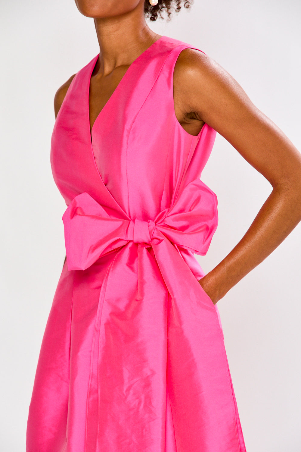 Pink dress with a large bow detail on a white background