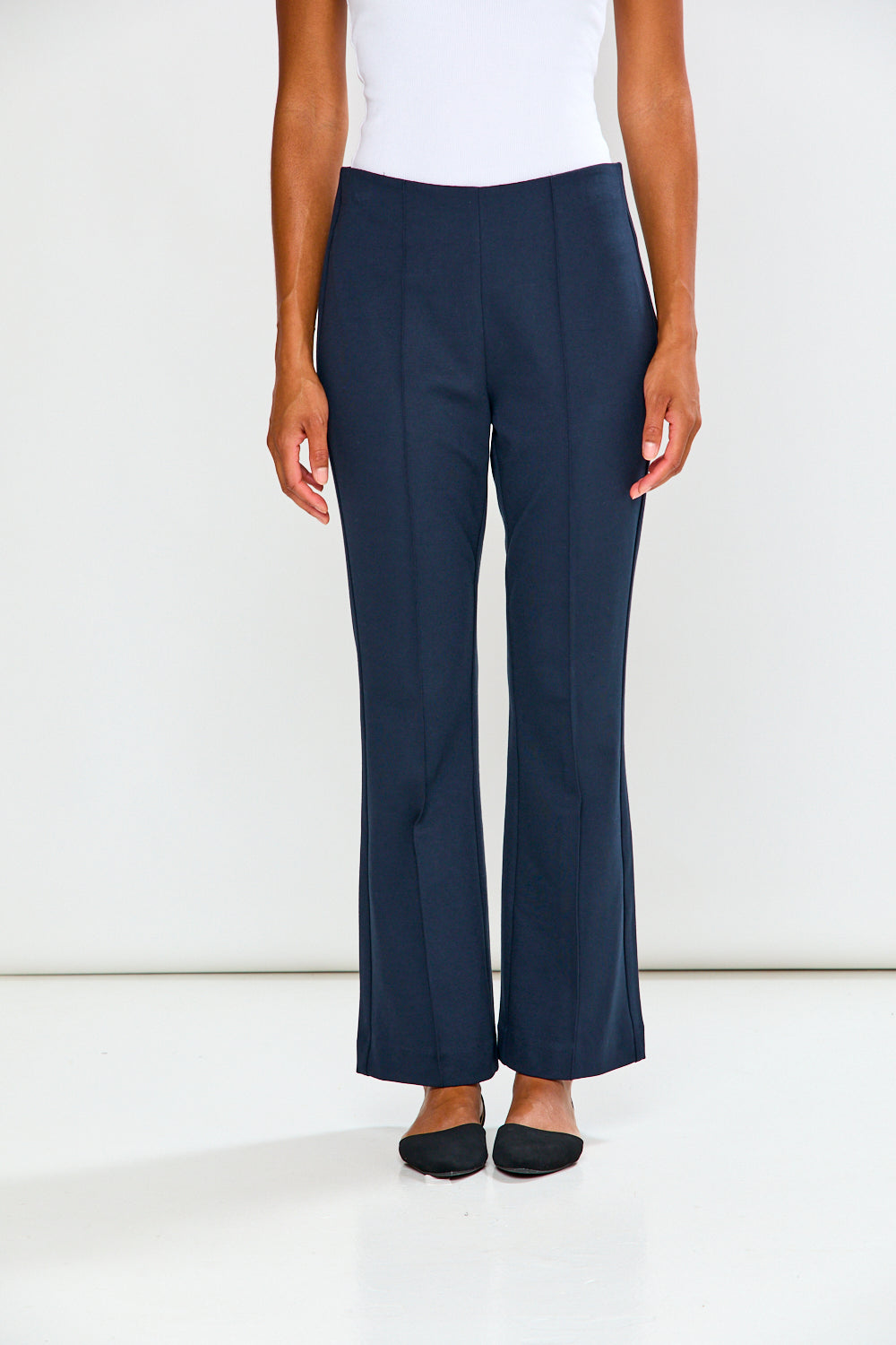 Navy pants worn by a person on a white background