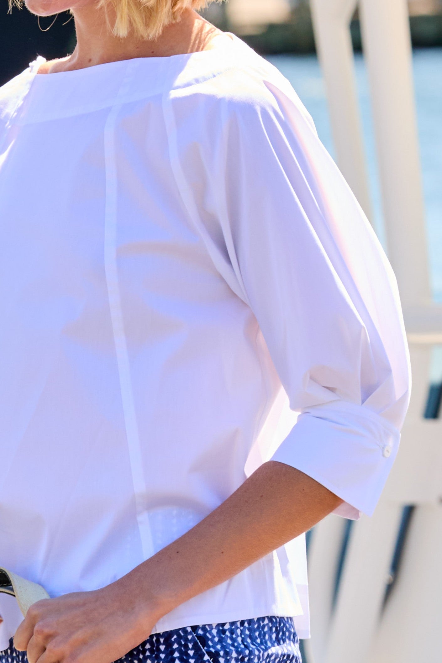 Woman in a white top and blue patterned shorts