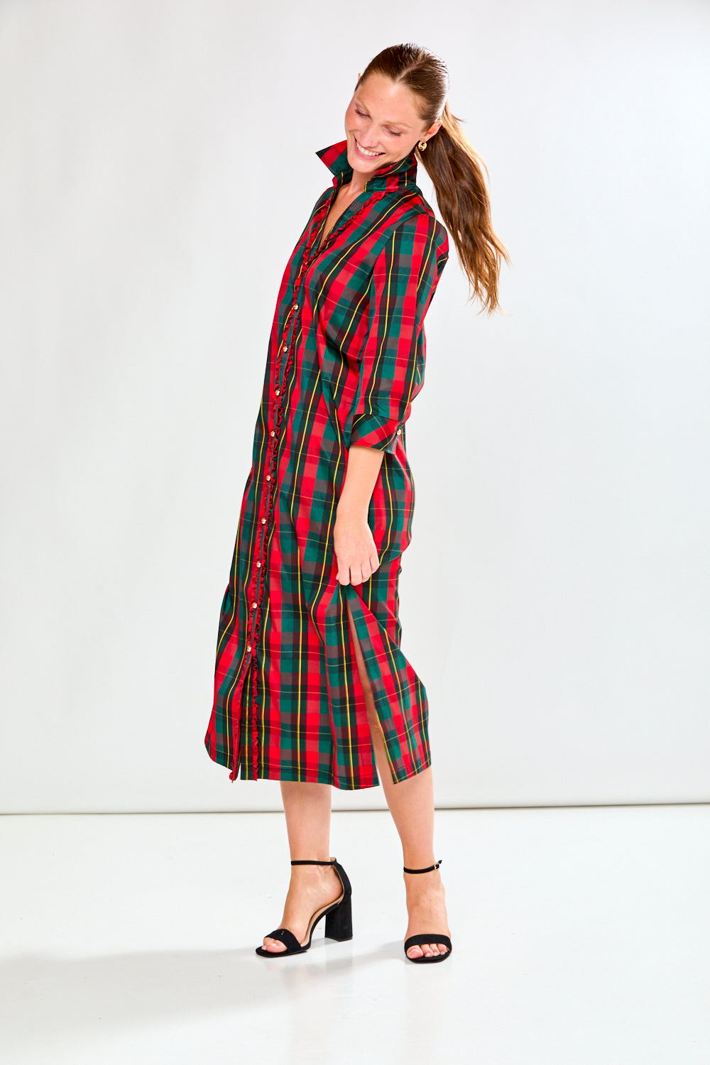 Woman wearing a red and green plaid dress on a white background