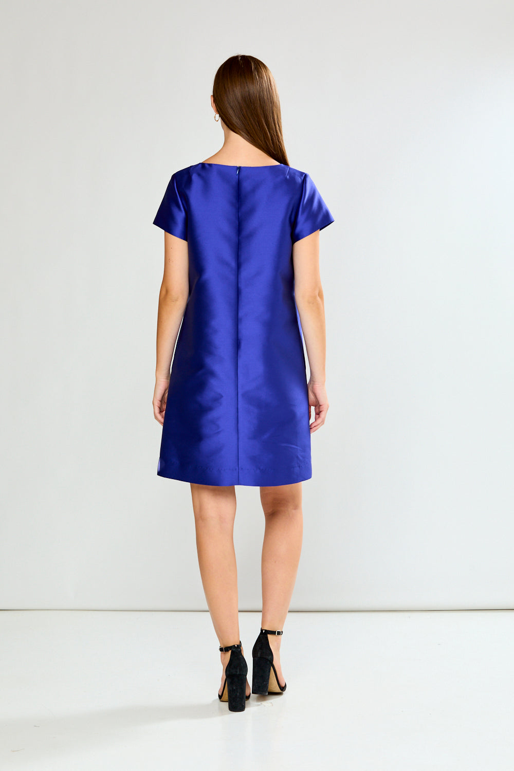 Woman wearing a blue dress against a white background