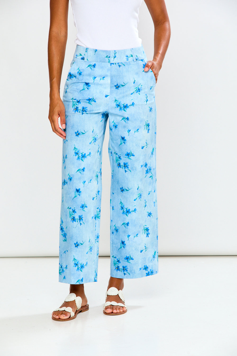 Person wearing light blue floral wide-leg pants on a white background