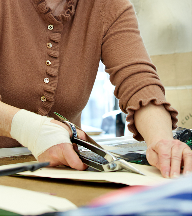 Person cutting paper with scissors in a blurred indoor setting