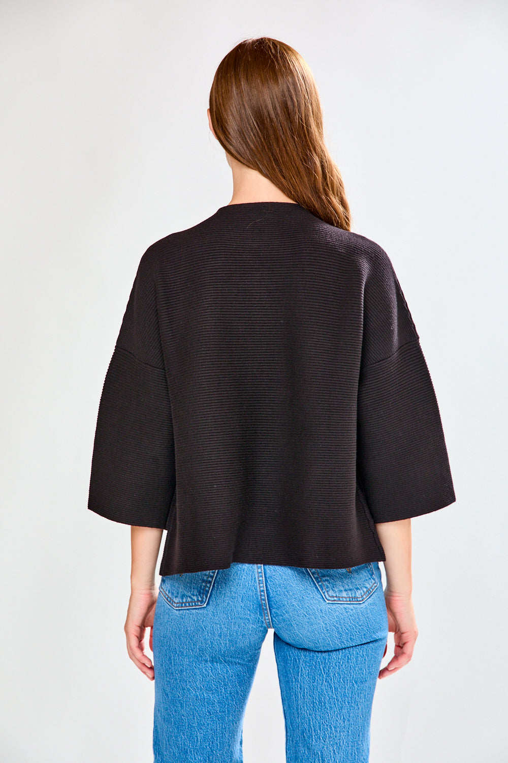 Woman in black ribbed sweater