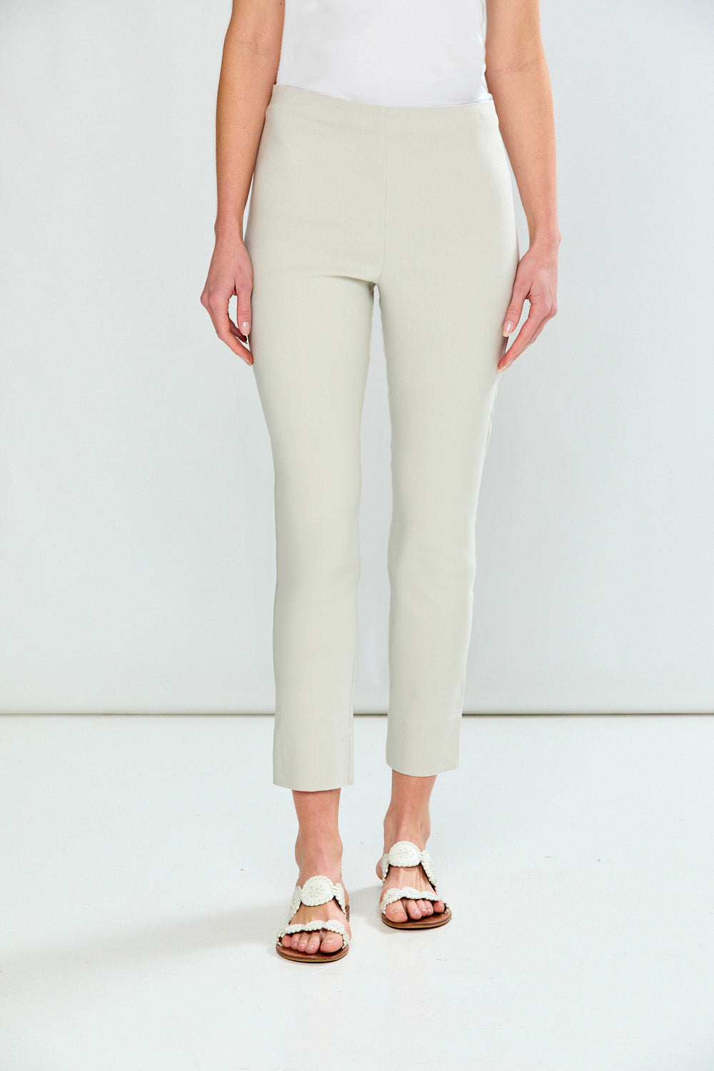 Person wearing light green pants on a white background