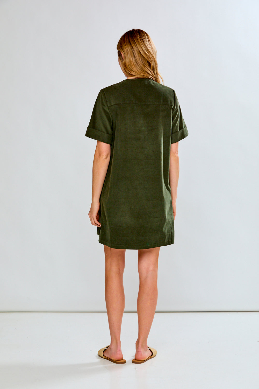 Woman wearing a green dress against a white background