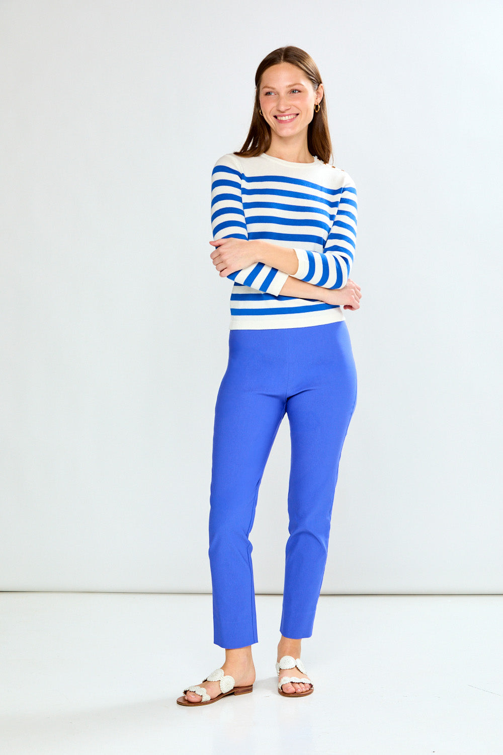 Woman wearing a blue and white striped sweater and blue pants on a white background