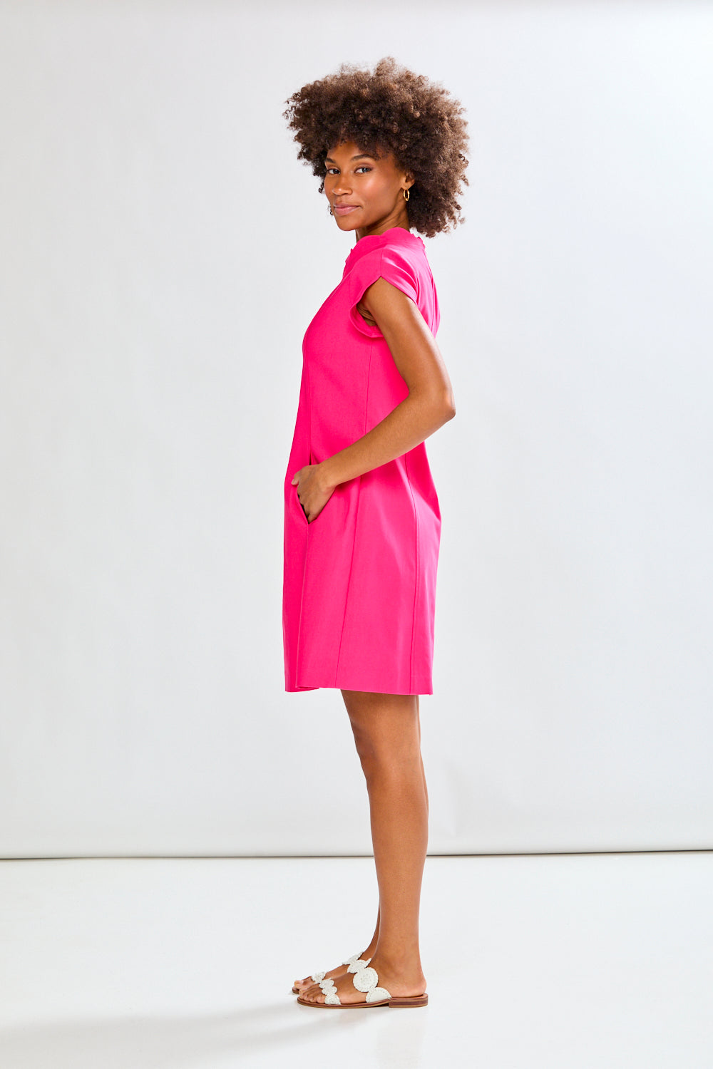 Woman wearing a bright pink dress against a white background