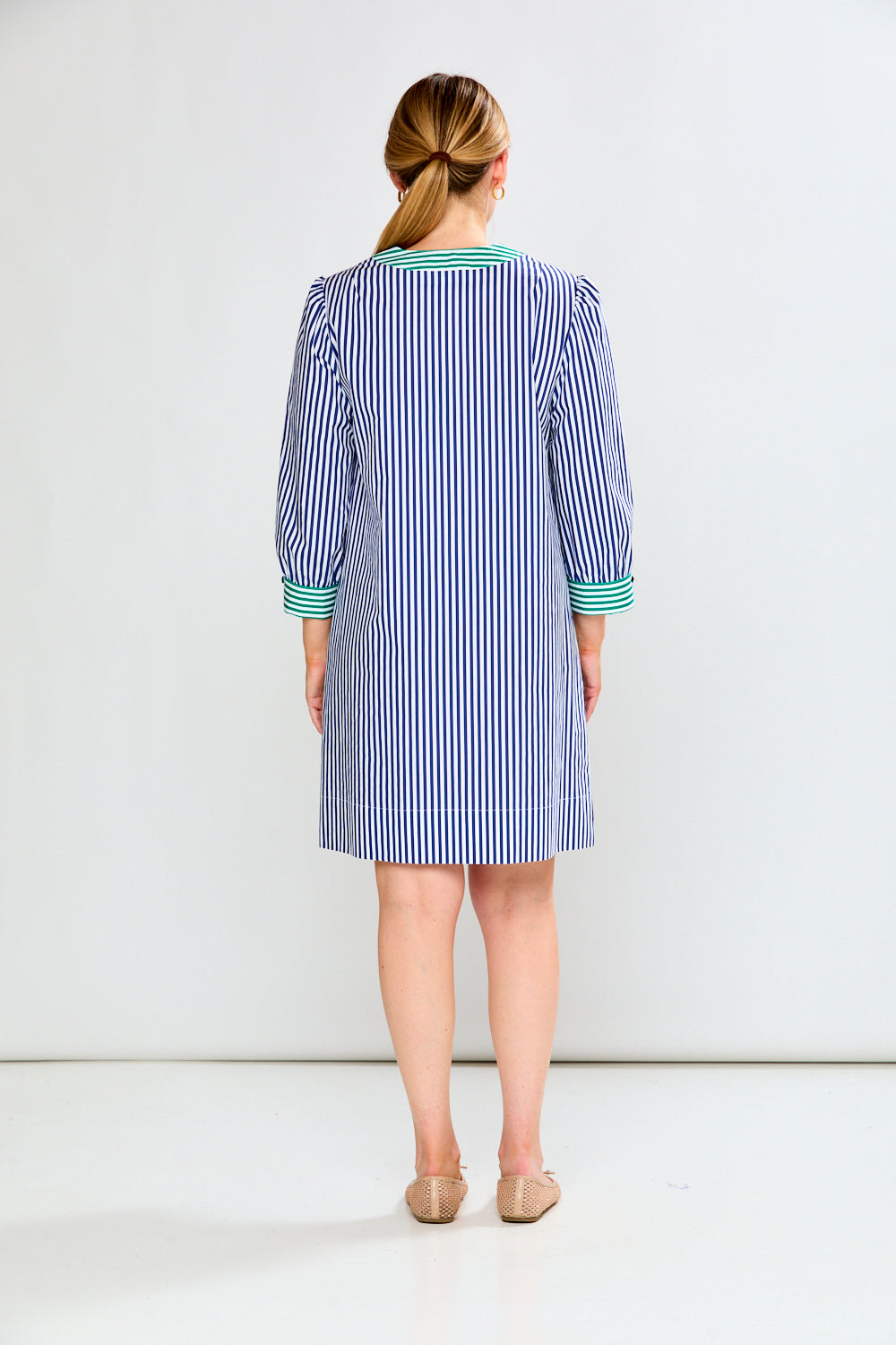 Woman wearing a blue and white striped dress on a white background