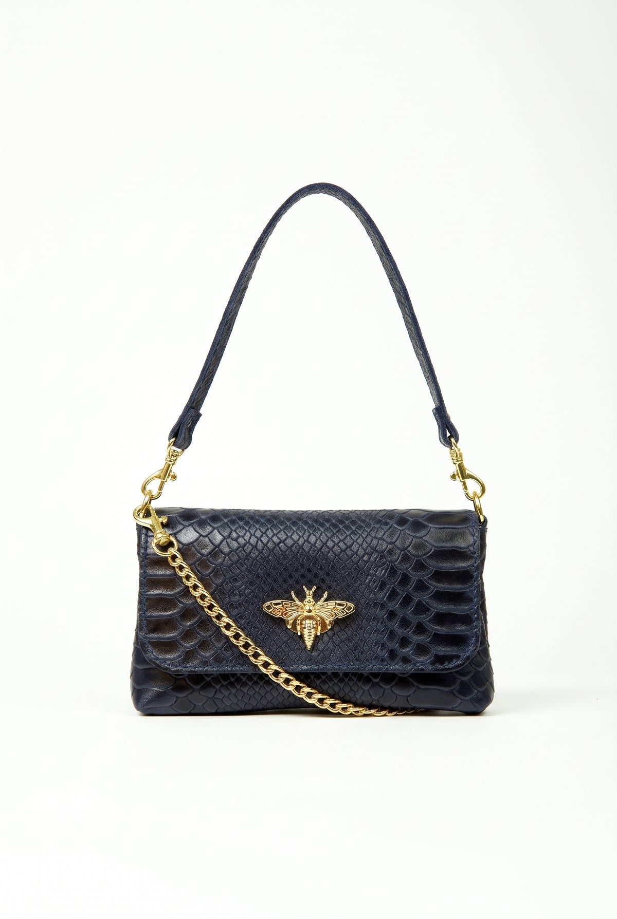A dark navy blue snakeskin shoulder bag with a gold-tone bee charm and chain strap, photographed against a plain white background.