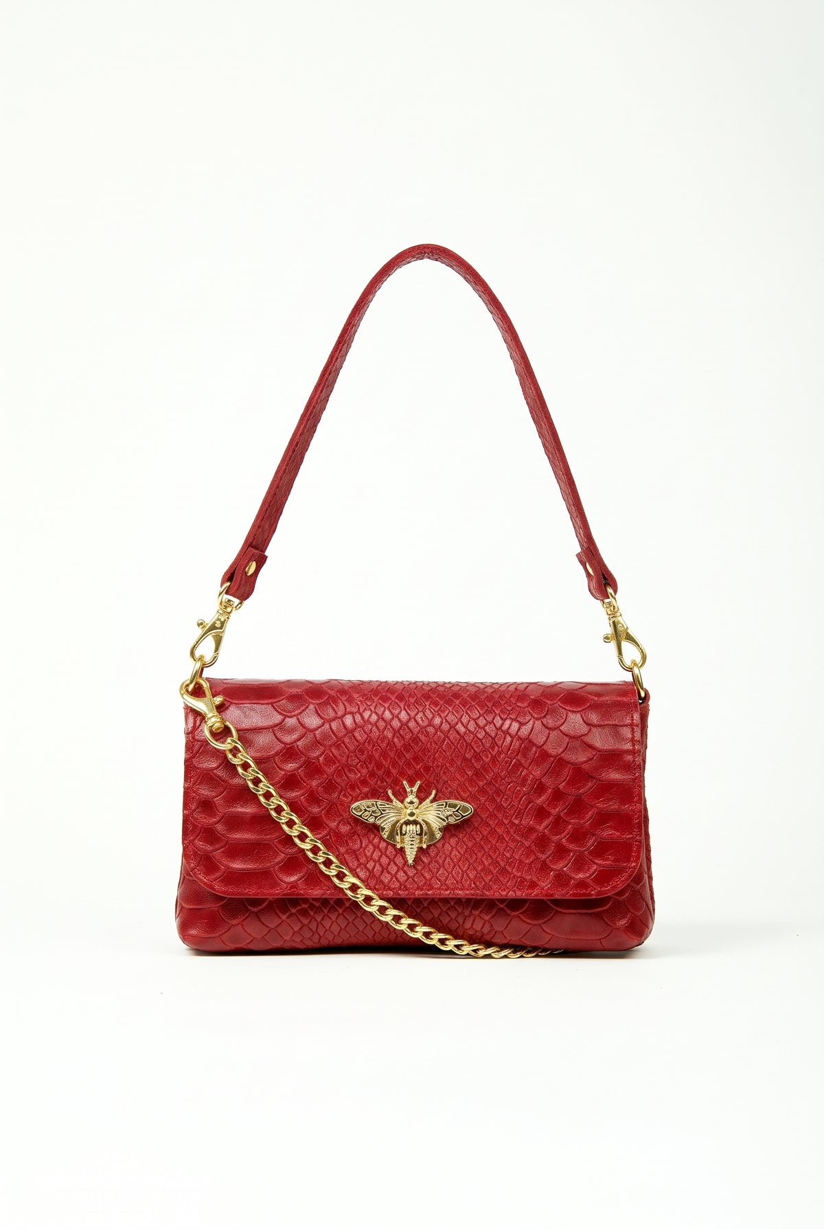 A red crocodile-embossed leather shoulder bag with a gold-tone bee logo on the front flap and a gold chain strap, shown against a plain white background.