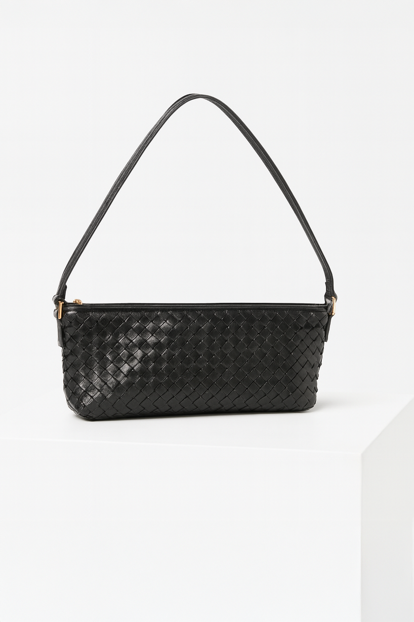 Black woven handbag on a white background