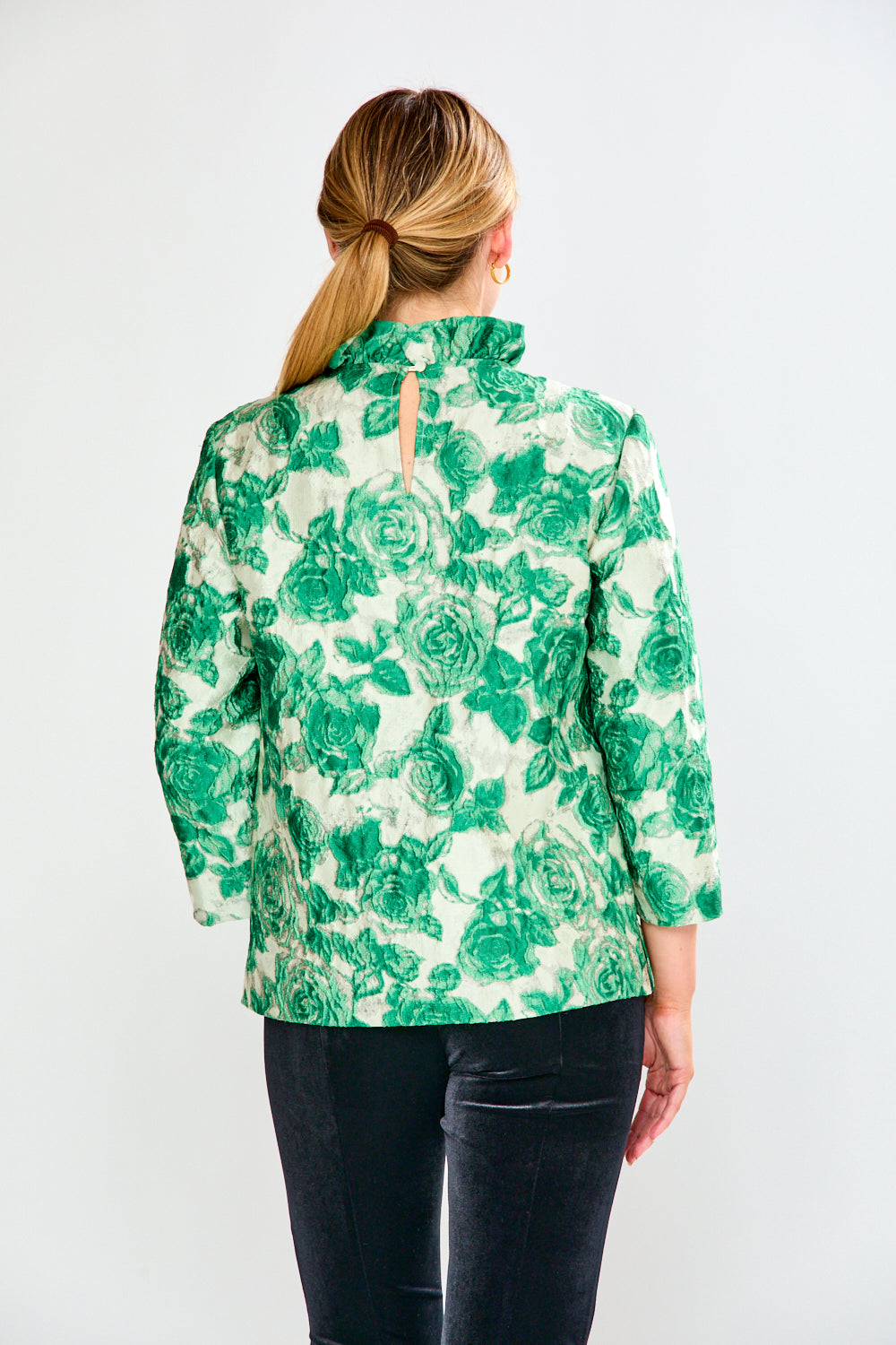 Woman wearing a green floral blouse against a white background