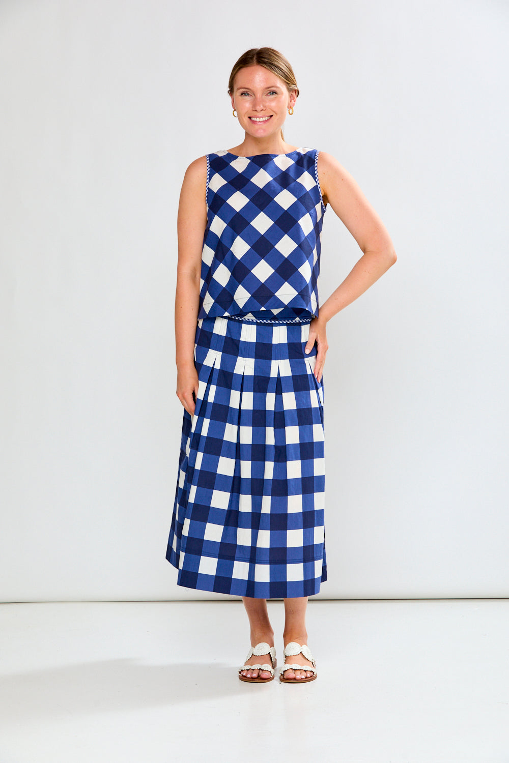 Woman wearing a blue and white checkered dress on a white background