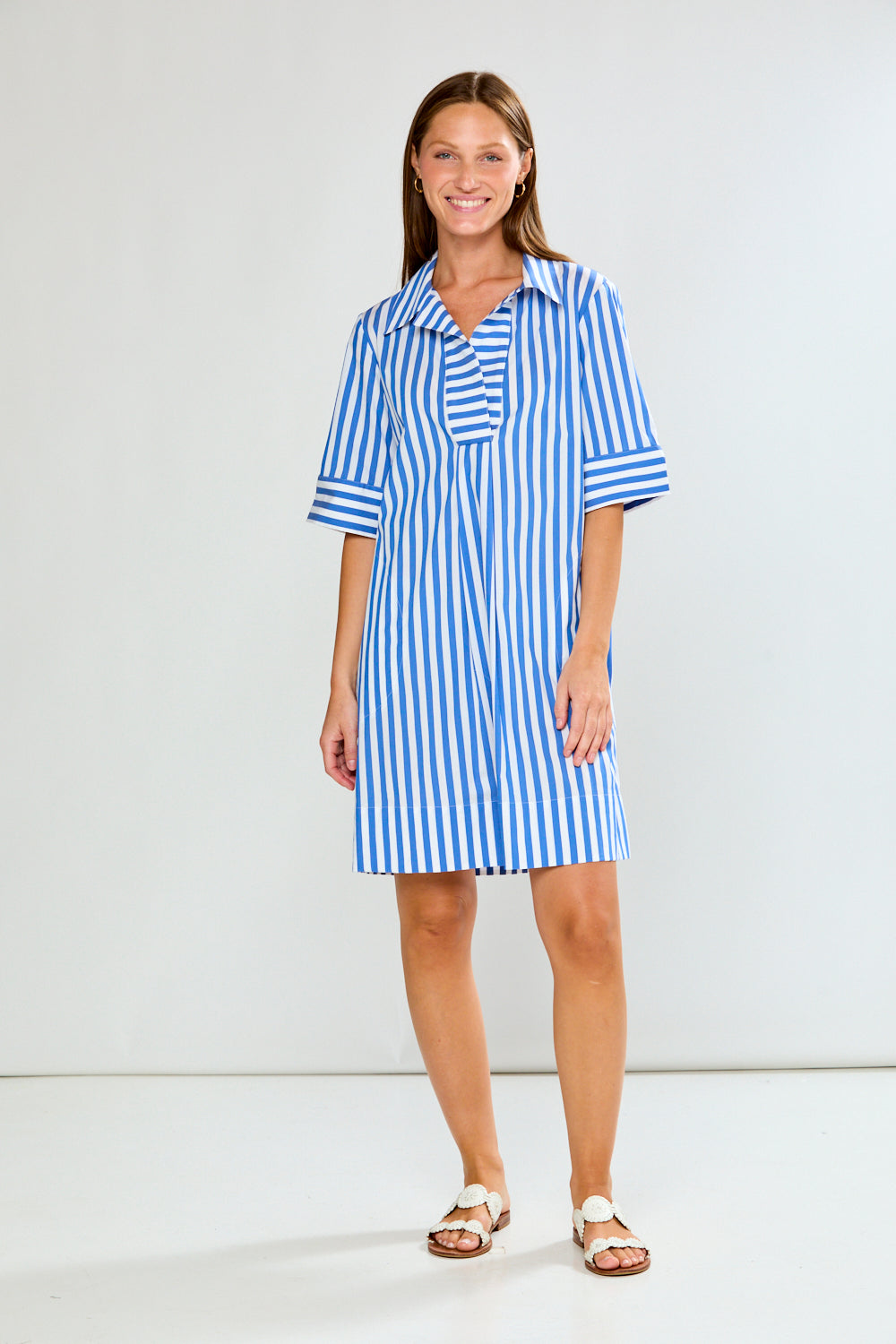 Woman wearing a blue and white striped dress on a white background