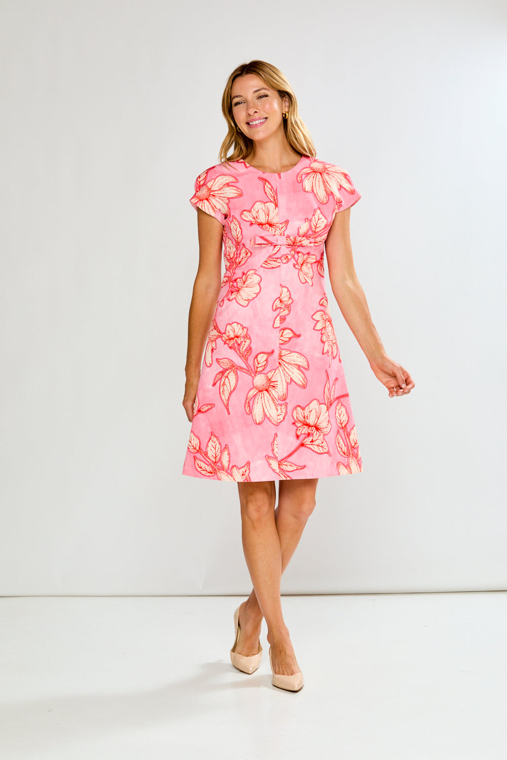 Woman wearing a pink floral dress on a white background