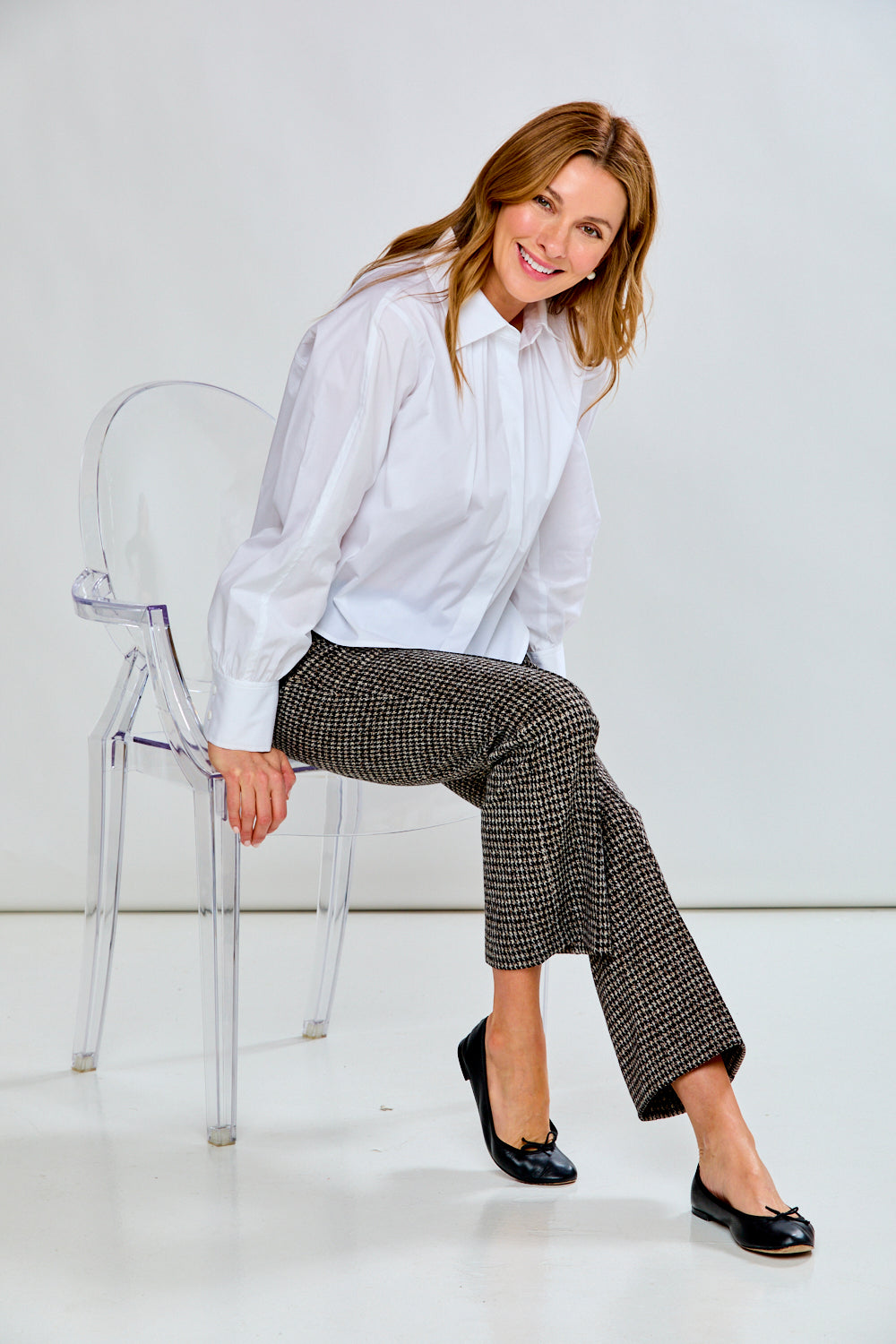 Person wearing houndstooth patterned pants on a plain background