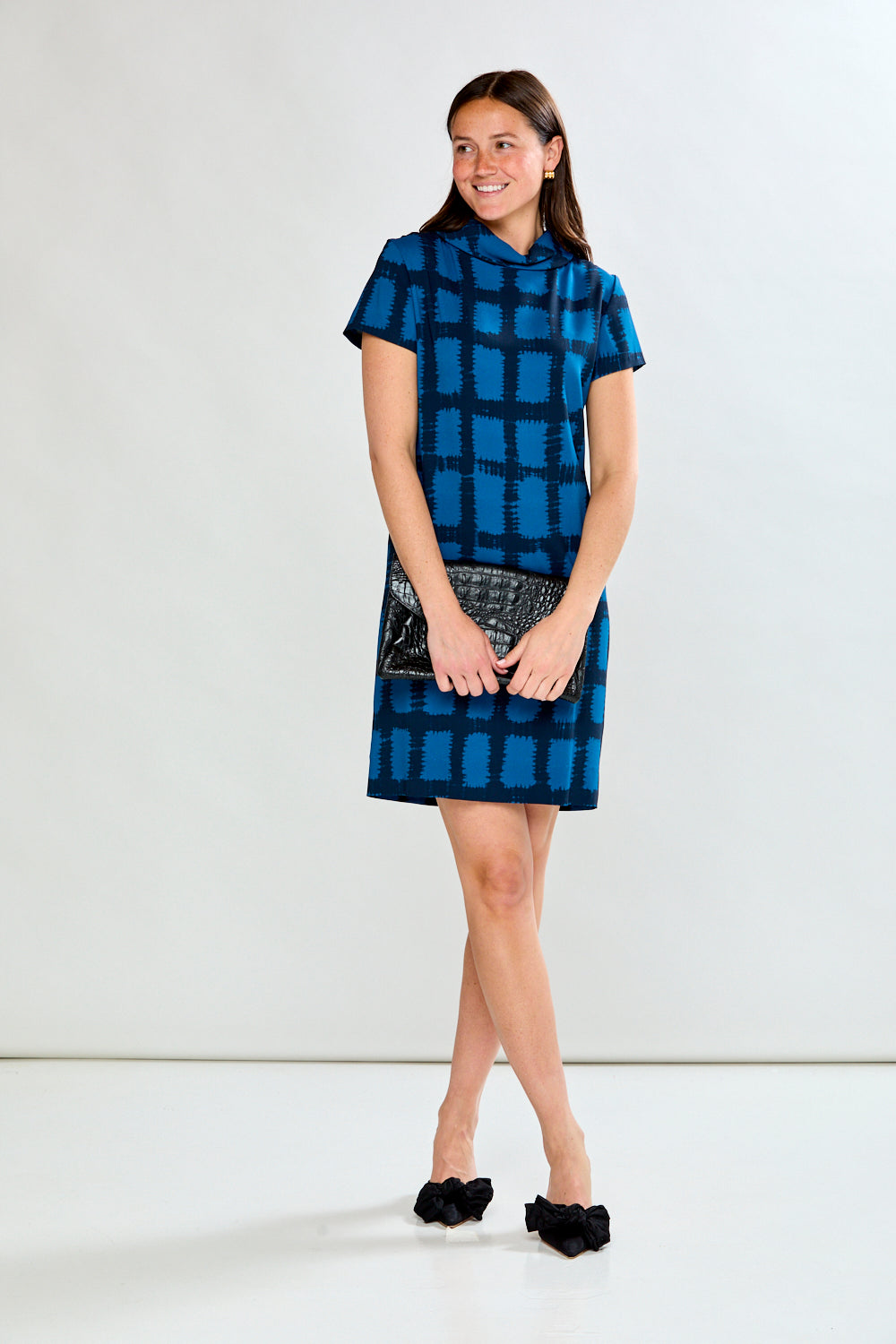 Woman wearing a blue checkered dress against a white background