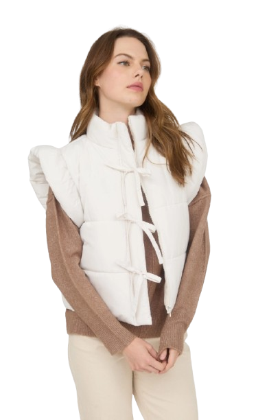 Woman wearing a white vest over a brown sweater on a white background
