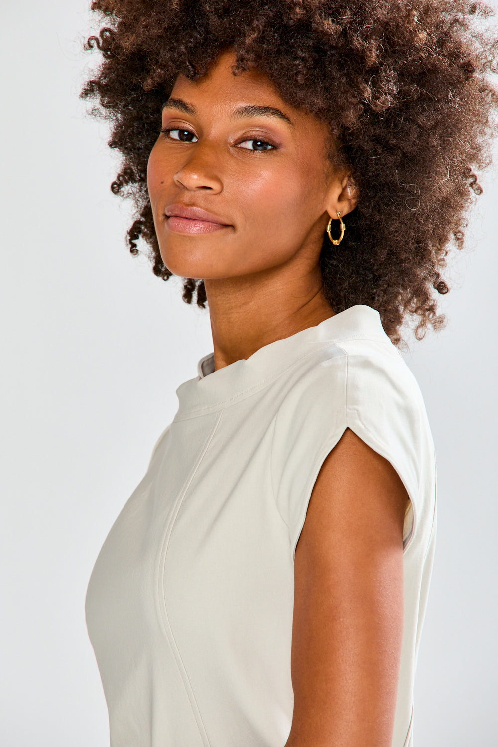 Woman wearing a stone dress against a plain background