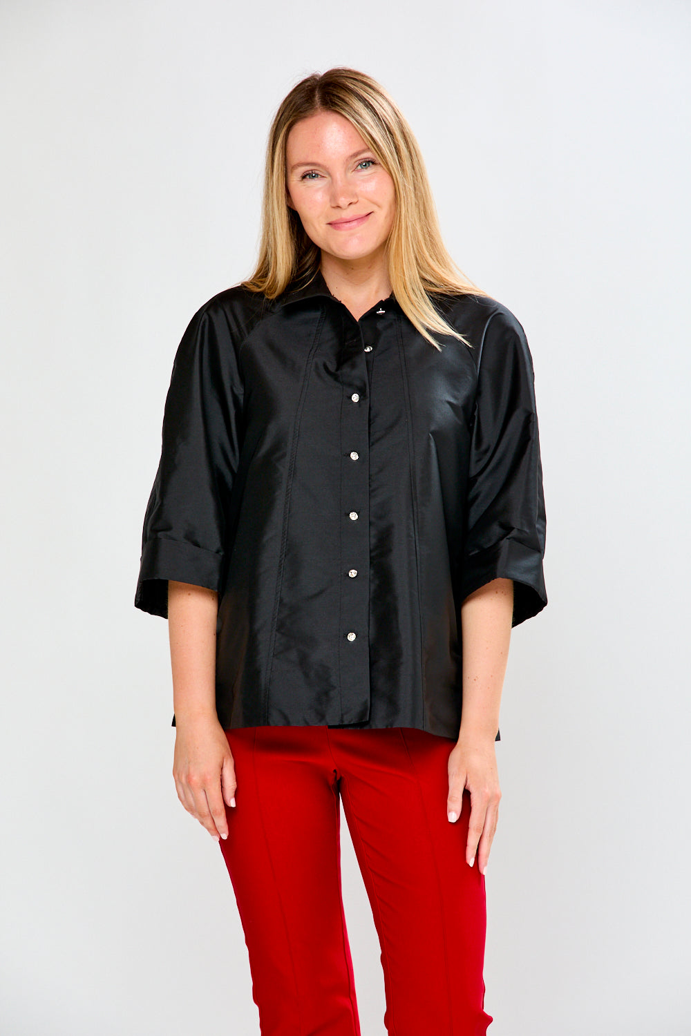 Woman wearing a black shirt and red pants on a white background