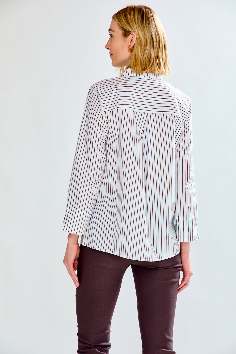 Woman wearing a striped shirt on a plain background